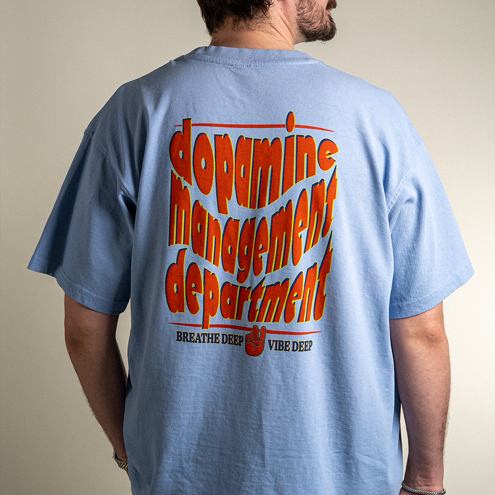 Close up back view of model wearing Breathe Deep Vibe Deep heavyweight cotton tee from Dopamine Management Department.