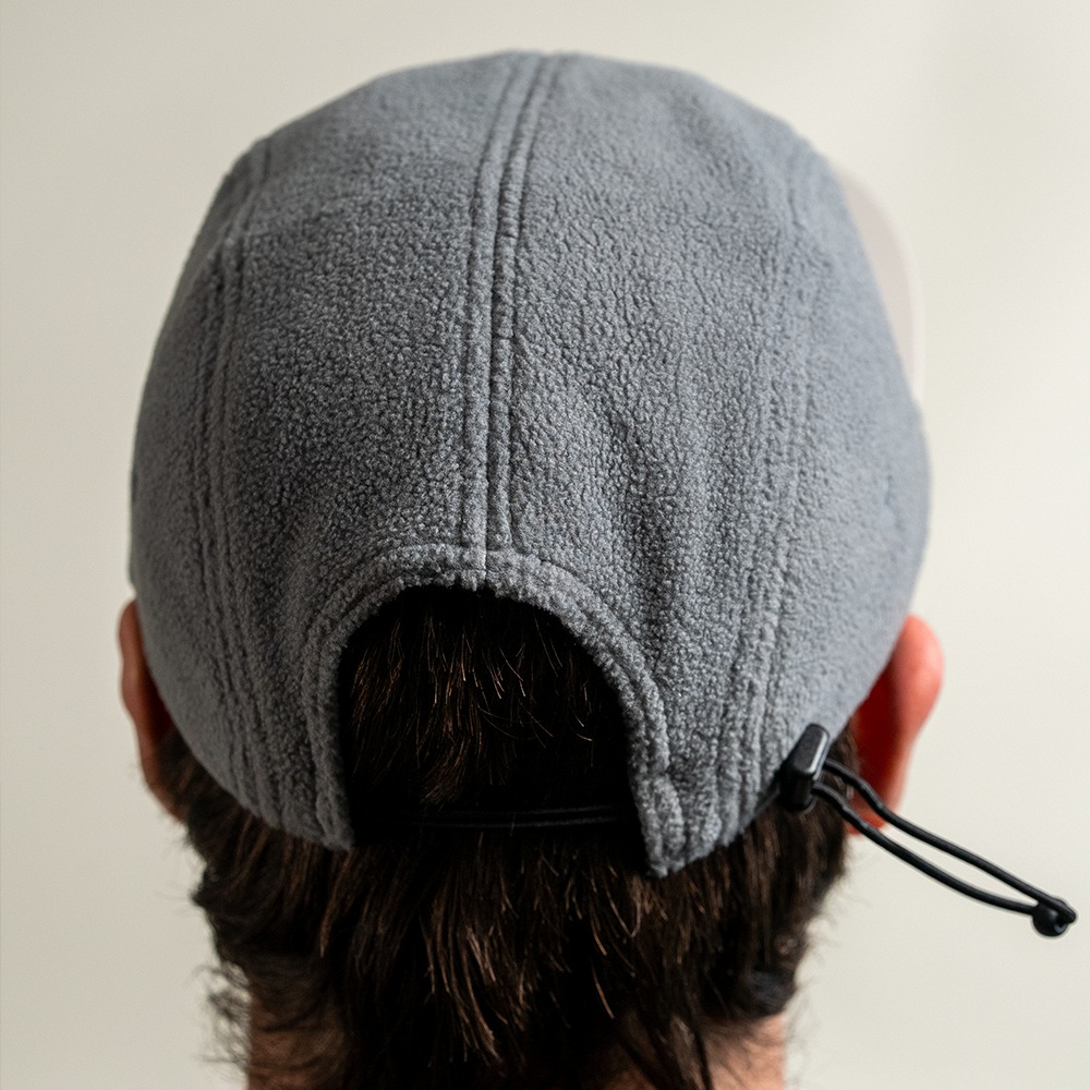 Back view of model wearing Skull Flower Fleece 5 Panel hat showing adjustable strap