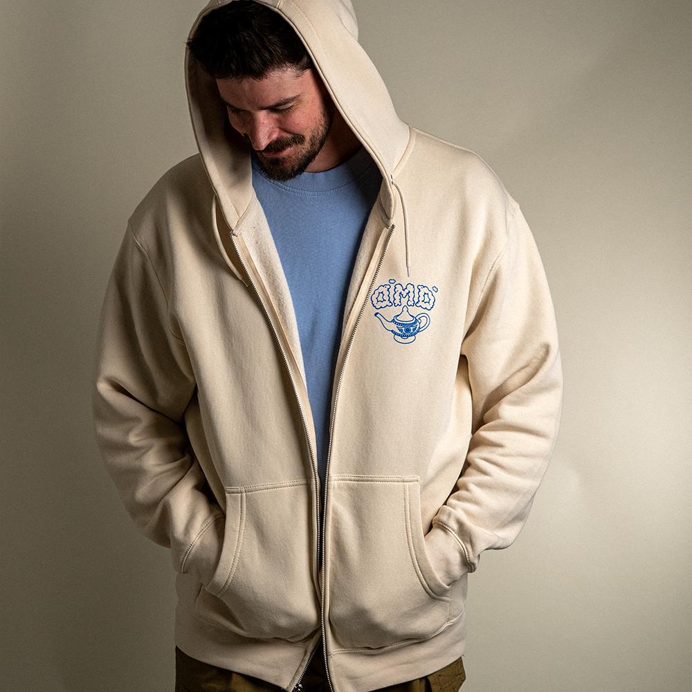 Front view of model wearing Be Your Own Genie zip up hoodie with hood up.