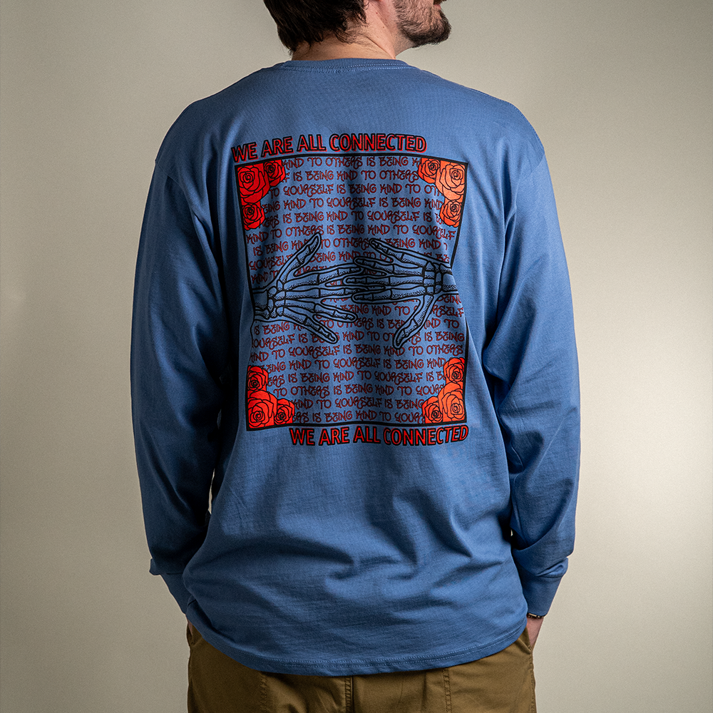 Model wearing blue Kindness Long Sleeve Tee – back graphic showing ‘Being Kind to Others’ repeating message
