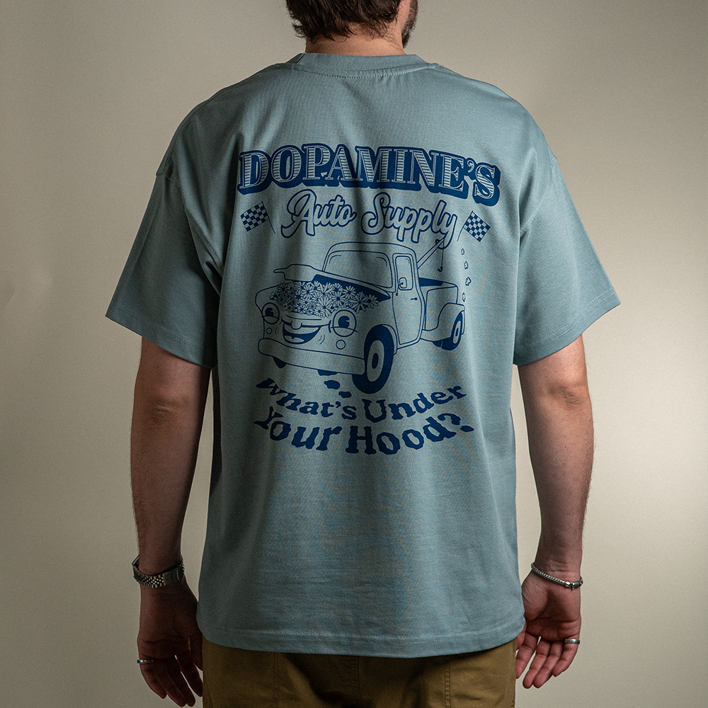 Back view of model wearing What's Under Your Hood Heavy Core Tee with oversized back design.