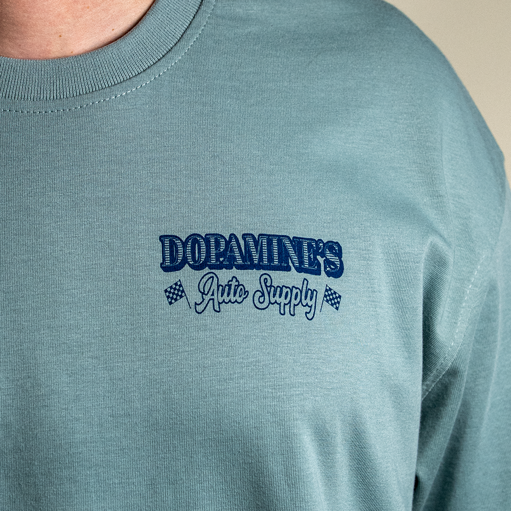 Close up of left chest of Dopamine's Auto Supply logo.