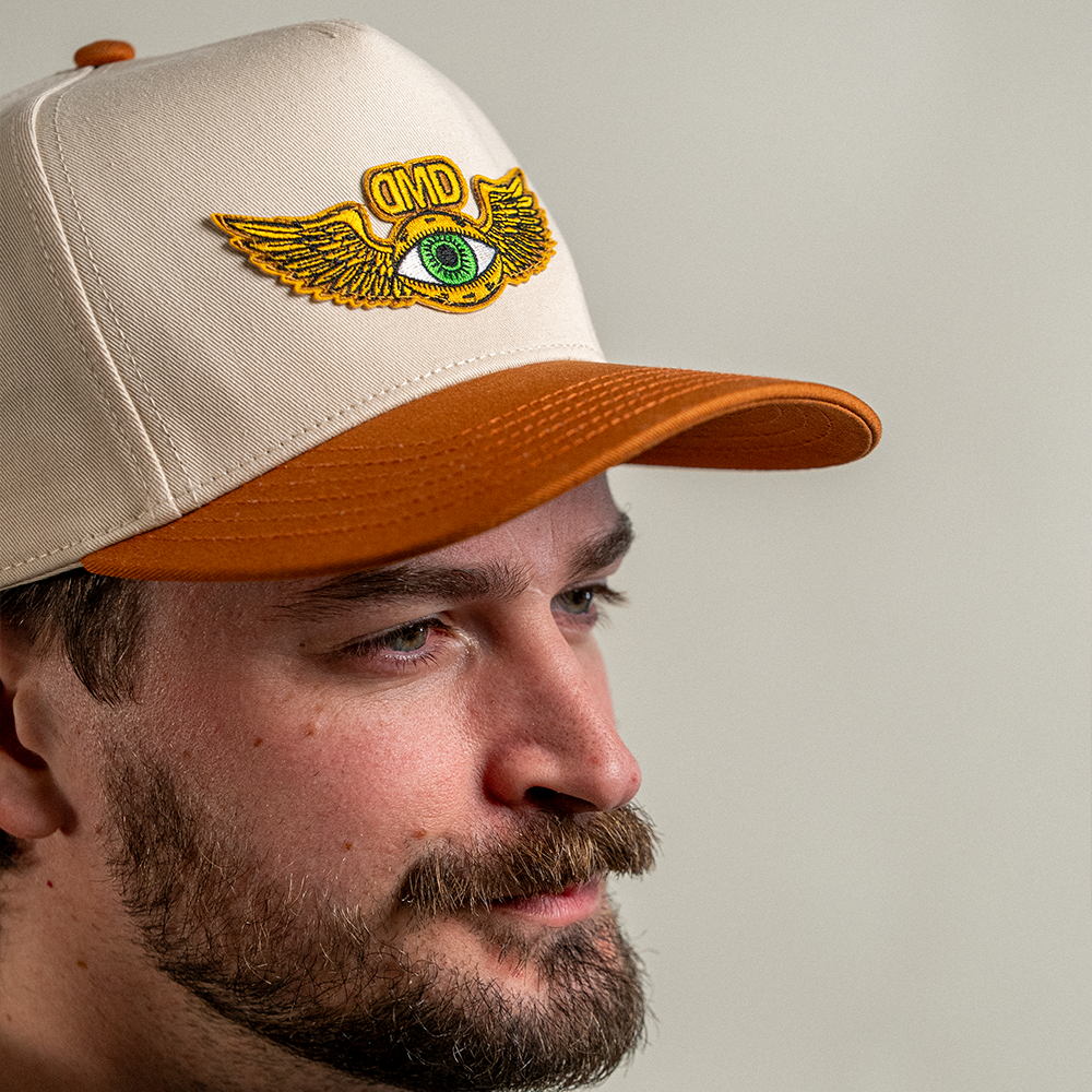 Side view of model wearing two tone flying eye hat