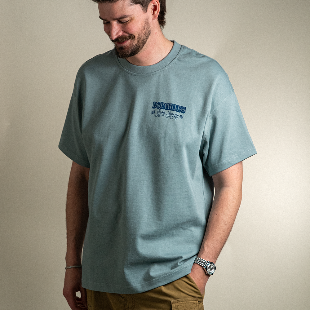 Front view of model wearing What's Under Your Hood Heavy Core Tee with left chest logo design.