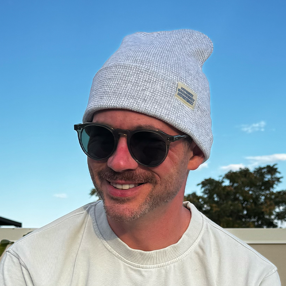 Model wearing Heather Beanie in grey & white with sunglasses