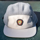 Close-up of Skull Flower Fleece 5 Panel hat on table highlighting PVC skull flower patch