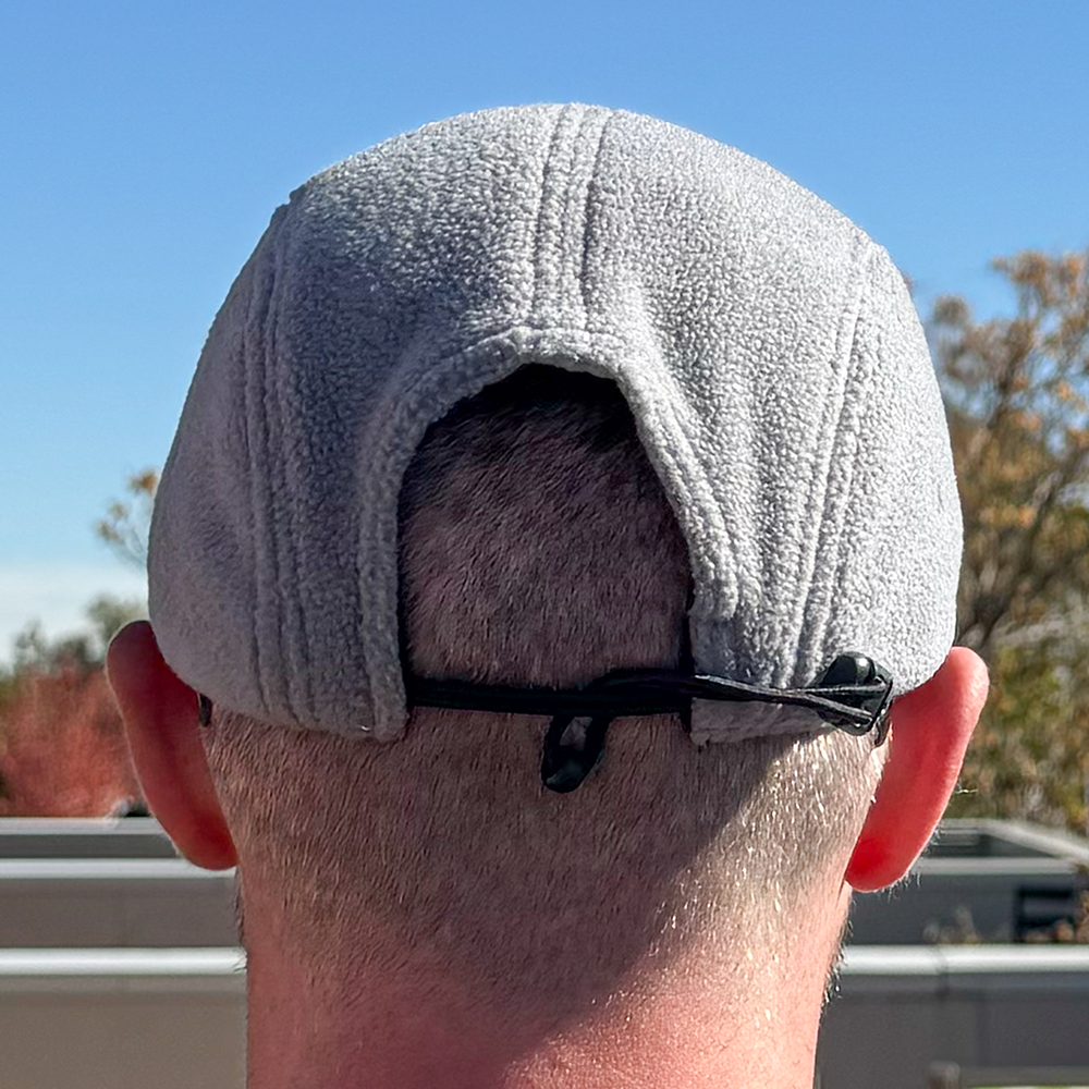 Back view of model wearing Skull Flower Fleece 5 Panel hat in natural outdoor light