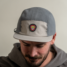 Front view of model wearing Skull Flower Fleece 5 Panel hat showing PVC skull flower patch