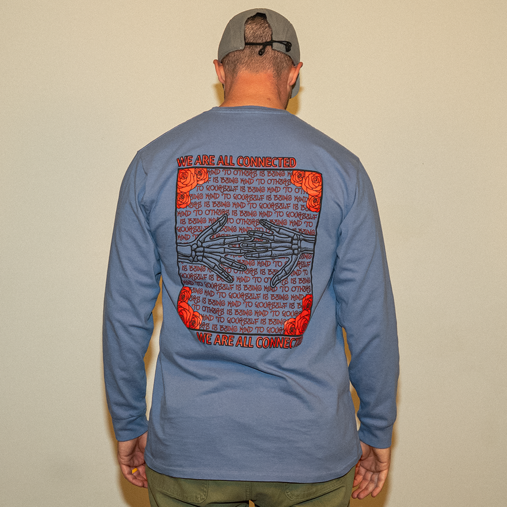 Model wearing blue Kindness Long Sleeve Tee – back graphic showing ‘Being Kind to Others’ repeating message