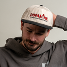 Man looking down while wearing the Rose Logo Hat.