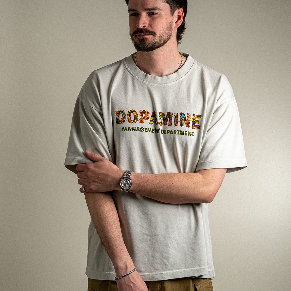 Model wearing Wallflower tee with Dopamine Management Department floral design on heavyweight cotton tee in light grey. 