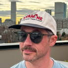 Side-angle lifestyle shot of the Rose Logo Hat worn with sunglasses.