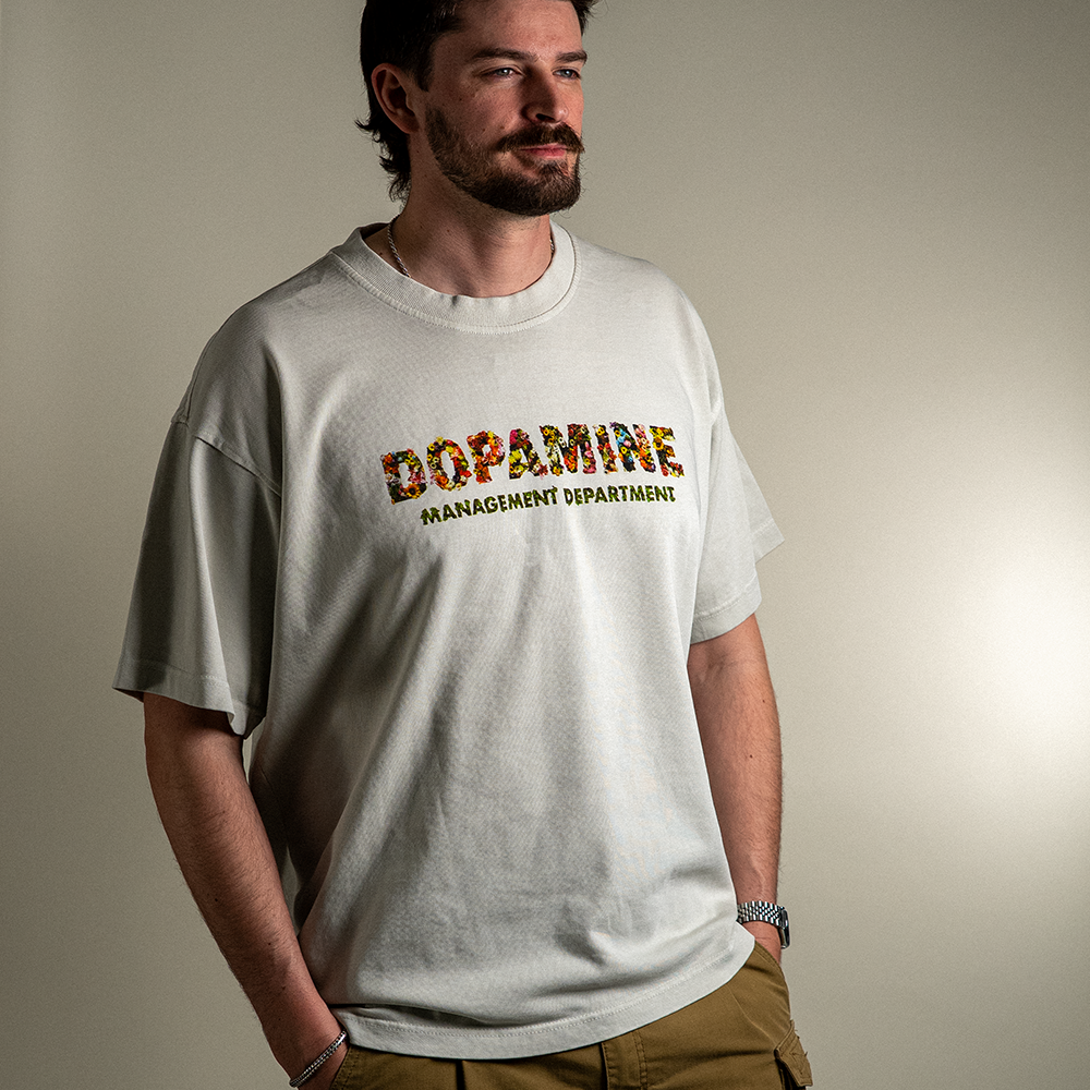 Model wearing Wallflower tee with Dopamine Management Department floral design on heavyweight cotton tee in light grey. 