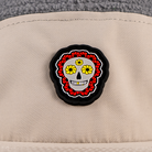 close-up of skull flower PVC patch detail on beige nylon panel