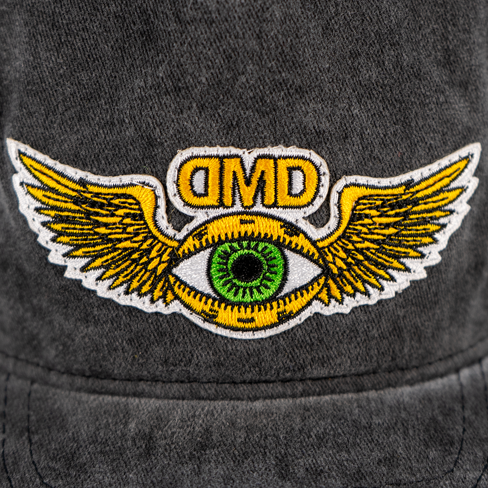 Close-up of embroidered flying third eye patch on vintage black DMD hat