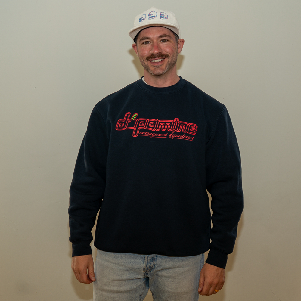 Smiling model in Dopamine Management Department cherry logo sweatshirt