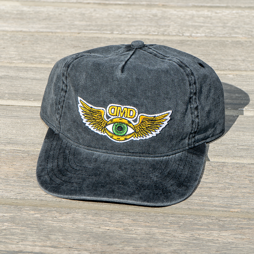 Front view of DMD Third Eye Vintage Hat with green eye and golden wings design