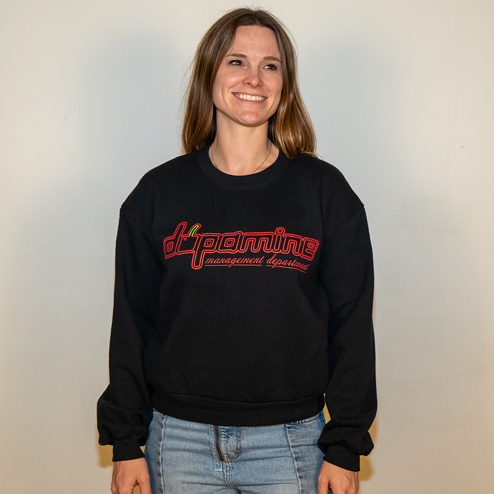 Female model smiling in black dopamine cherry logo crewneck