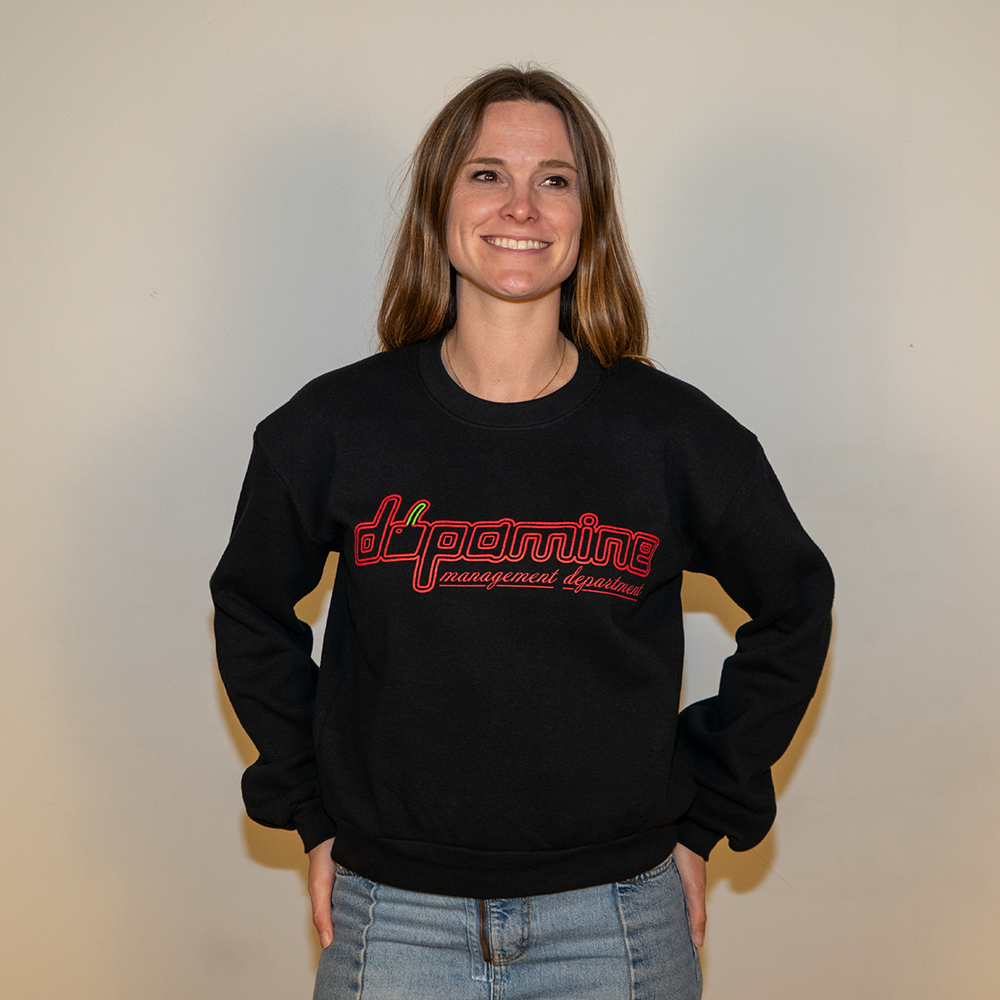 Female model smiling in black dopamine cherry logo crewneck