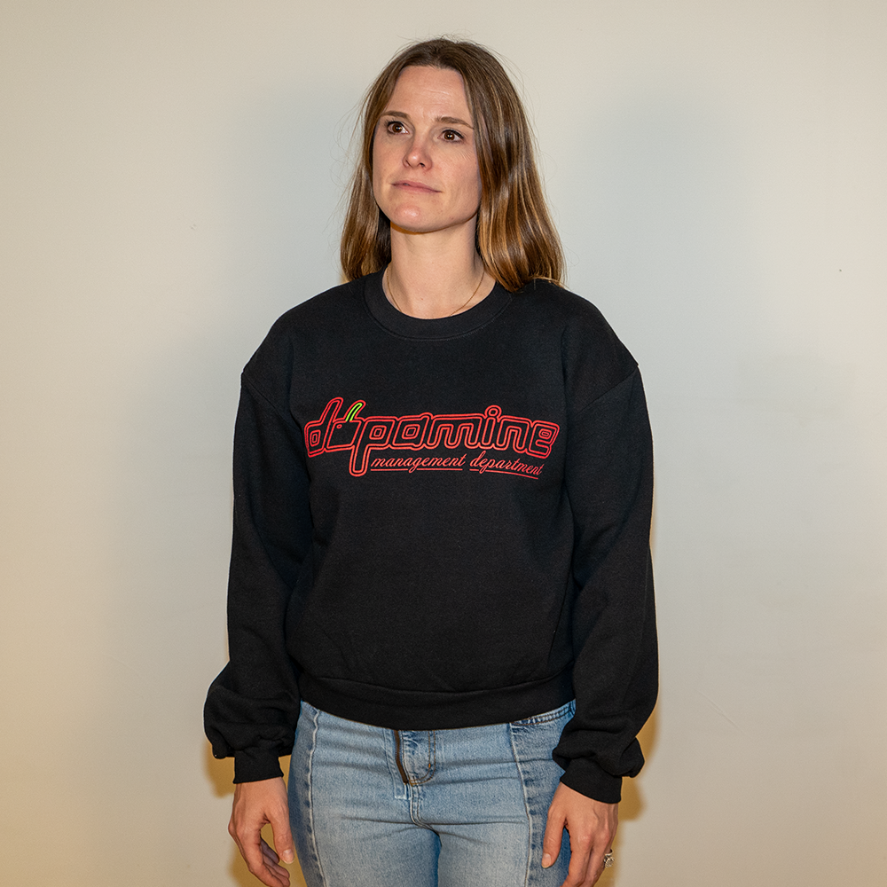 Female model smiling in black dopamine cherry logo crewneck
