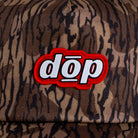 Close-up red rubber dōp logo patch on camo canvas hat