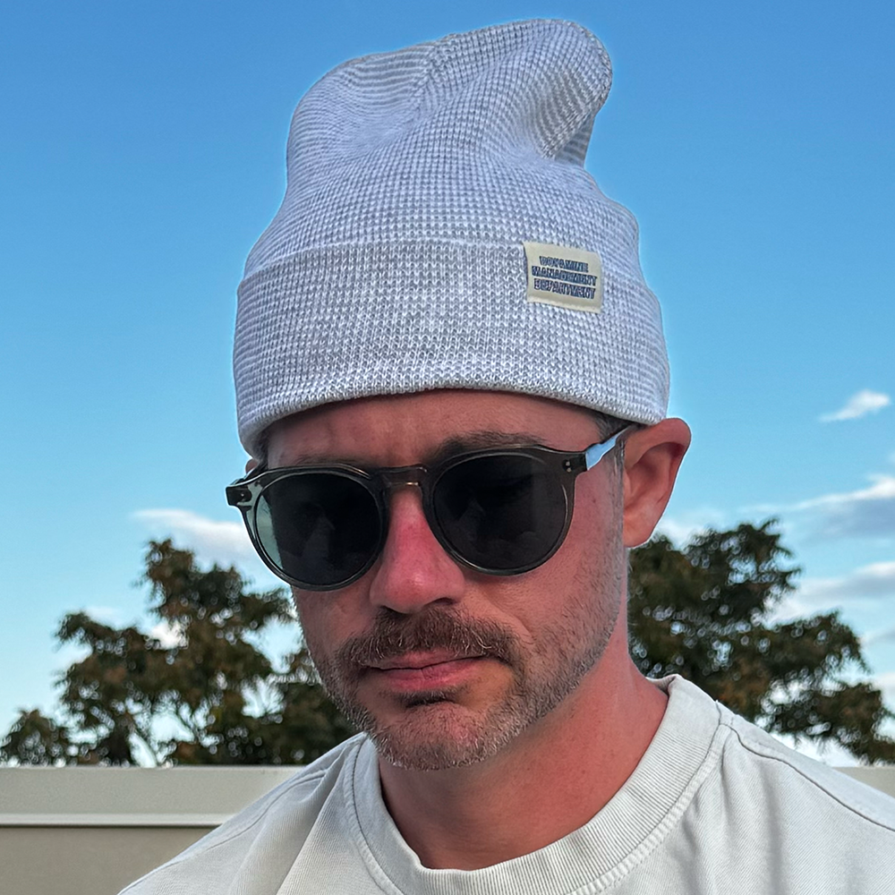 Model wearing Heather Beanie in grey & white with sunglasses