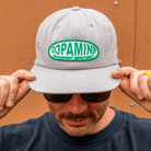 Person wearing a gray cap with 'Dopamine Management Department' logo.