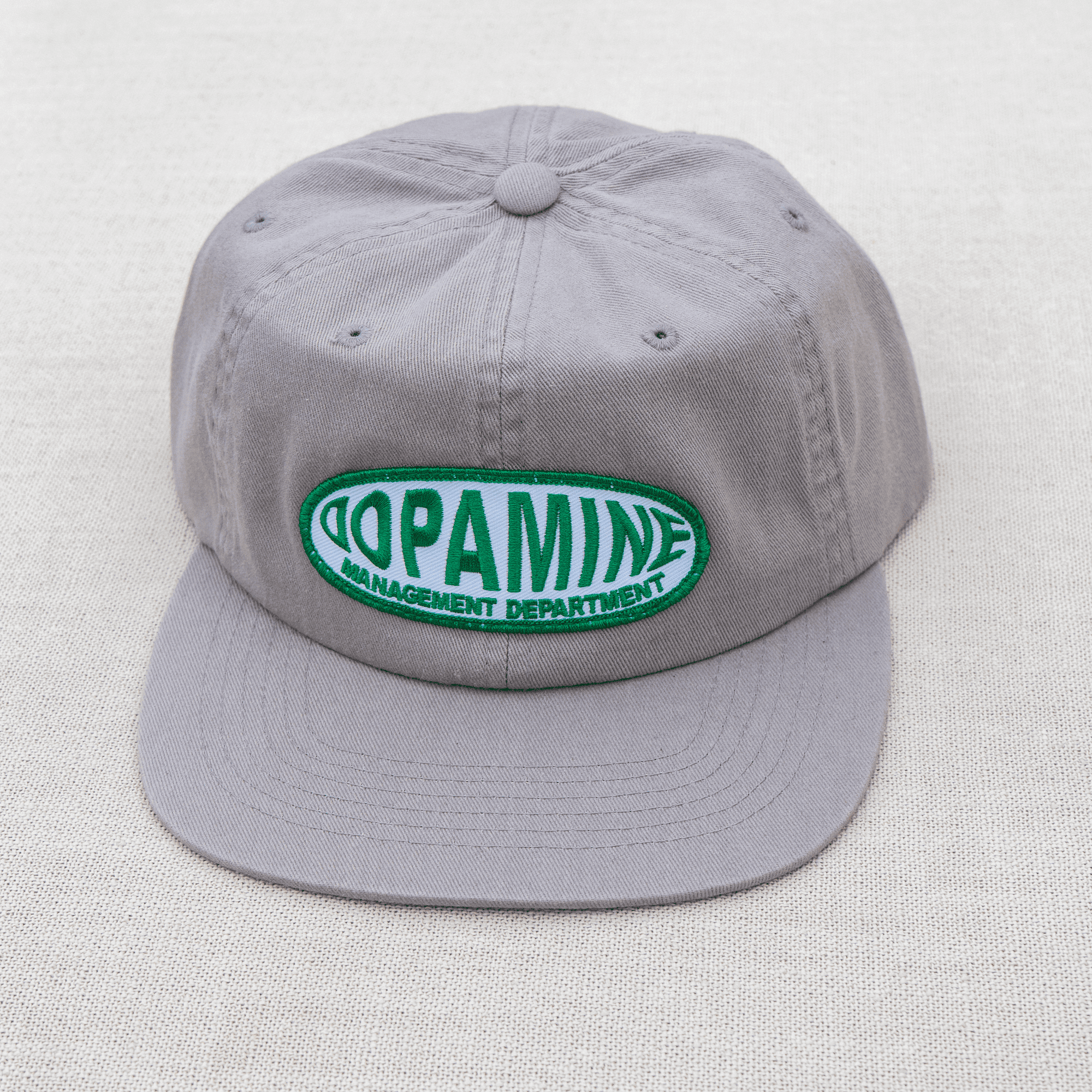 Gray cap with a green and white logo on a light gray background
