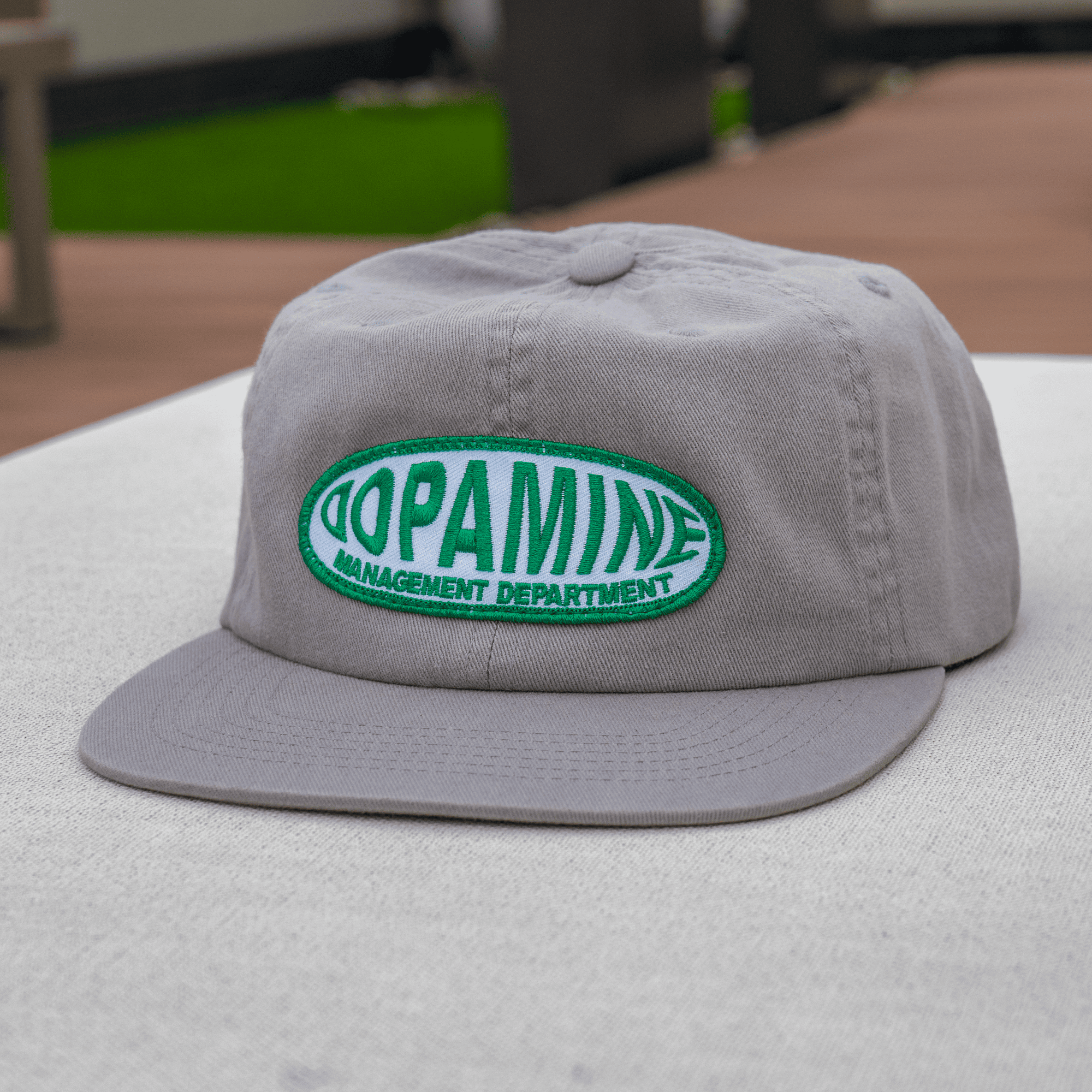 Gray cap with green and white text on a blurred background