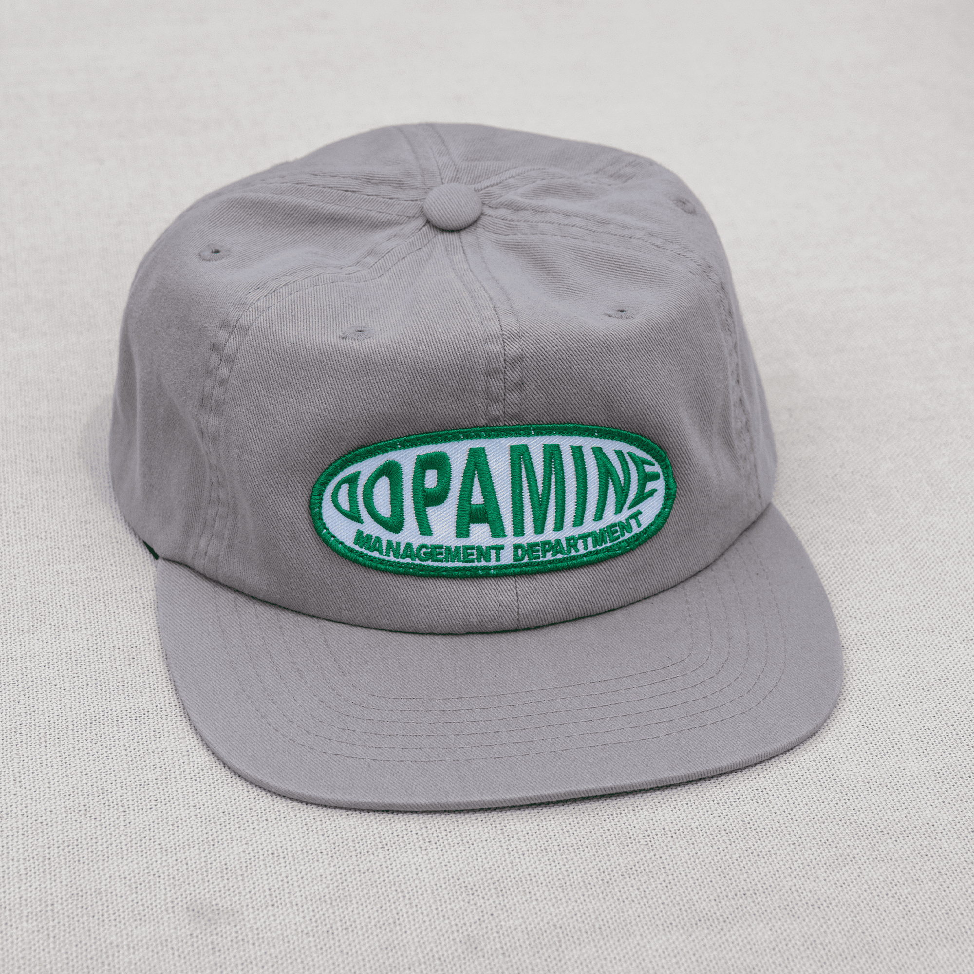 Gray cap with a green and white logo on a light gray background